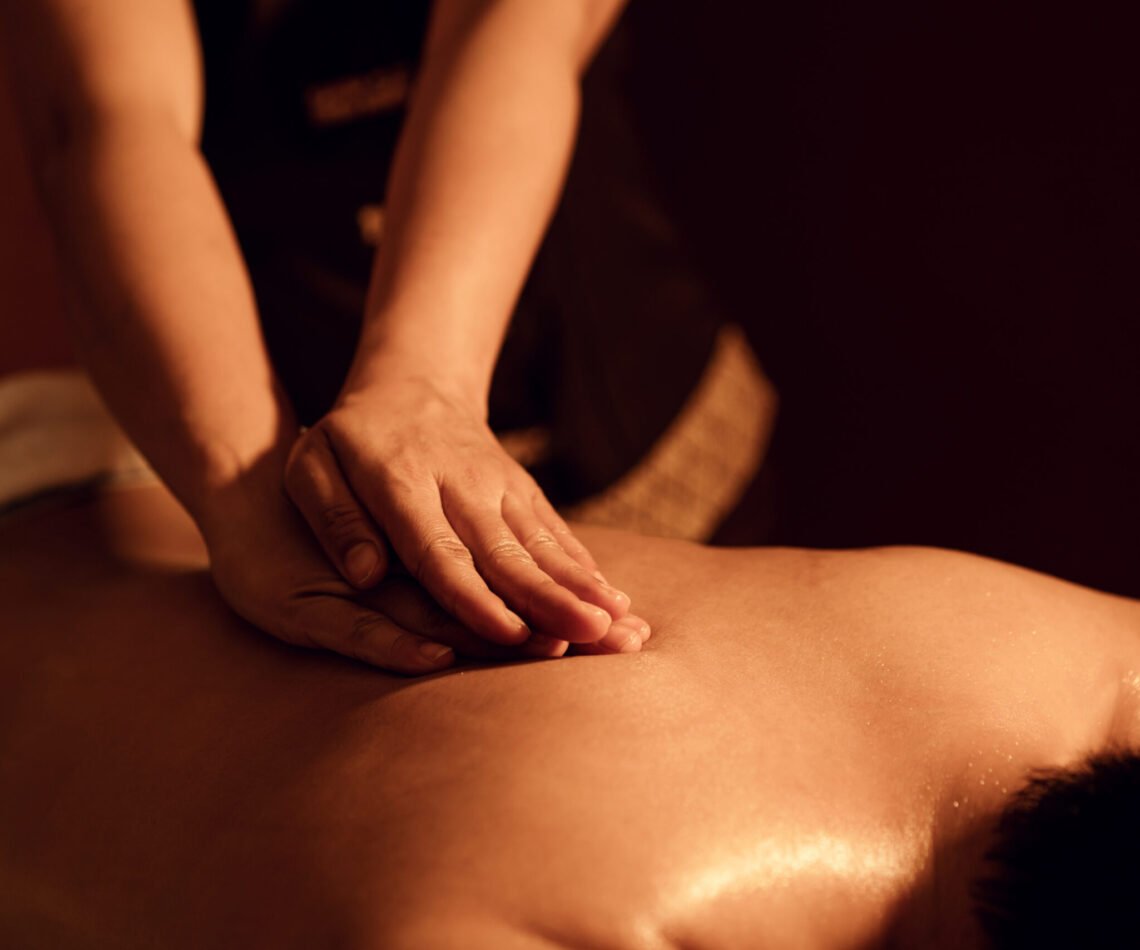 Masseuse hand massage aroma on back a man customer in cosmetology spa centre.