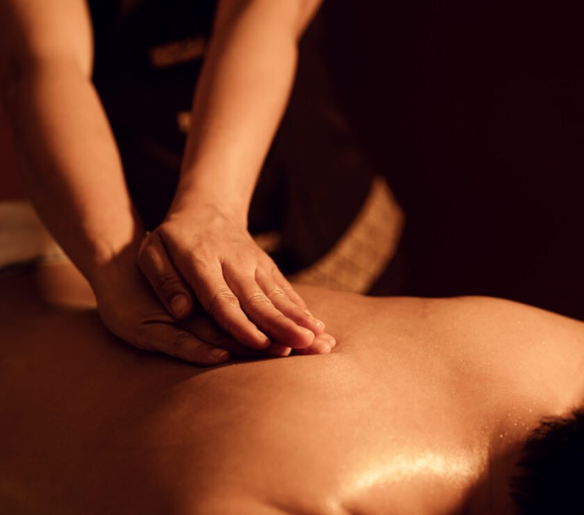 Masseuse hand massage aroma on back a man customer in cosmetology spa centre.